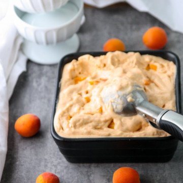 A bowl of ice cream on a table, with Apricot and Cream